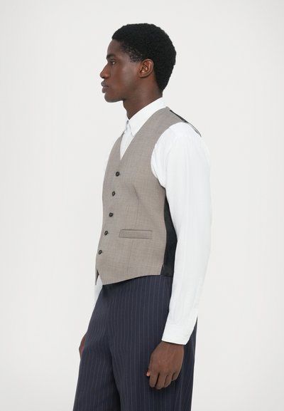 Grå rutete vest med V-hals, seks knapper og sidelommer; sammen med en hvit skjorte med krage og marineblå stripete bukser.