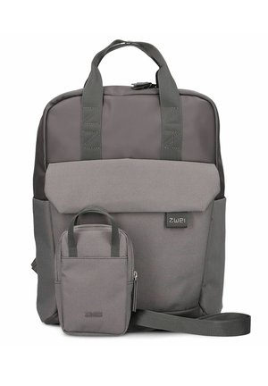 Sac à dos en tissu gris avec une poche avant, deux poignées supérieures et une sangle d'épaule réglable. Il présente un design simple et une taille modérée.