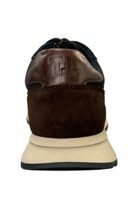 Heren sneaker met een marineblauwe bovenkant, leren hak in bruin en suede accenten in bruin. Voorzien van een gestructureerde rubberen zool en een logo op de hak.