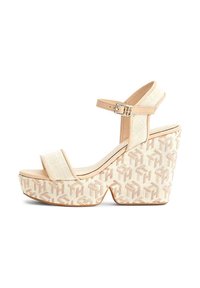 Sandali platform beige con tomaia intrecciata, cinturino alla caviglia regolabile e zeppa testurizzata caratterizzata da un motivo geometrico con logo.
