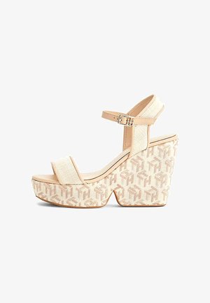 Sandali platform beige con tomaia intrecciata, cinturino alla caviglia regolabile e zeppa testurizzata caratterizzata da un motivo geometrico con logo.