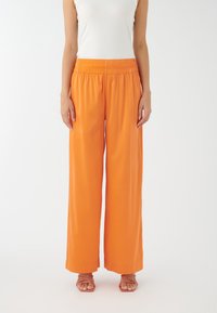 Breda högmidjade byxor i ett livligt orange tyg med en mjuk textur. Har elastiskt midjeband för komfort.