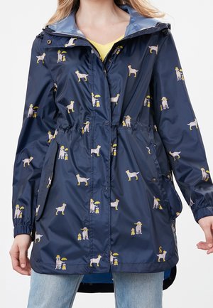 Meriveden vedenpitävä takki, jossa on joustava vyötärö. Takissa on toistuva kuvio vaaleanvärisistä koirista ja lapsista. Sileä, kiiltävä pinta.