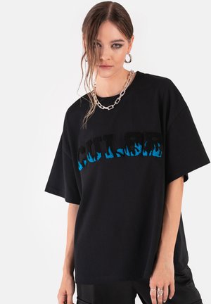 Czarna, oversize koszulka z krótkim rękawem, z niebieskim wzorem płomieni na teksturze napisu "COLOR". Okrągły dekolt i miękki materiał bawełniany.