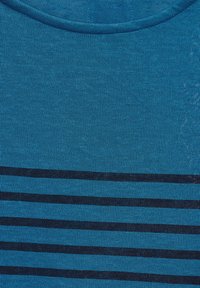 Sininen puuvillapaitaa, jossa on vaaleansiniset vaakasuorat tummansiniset raidat, ribbitekstuuri ja klassinen pyöreä kaula-aukko.