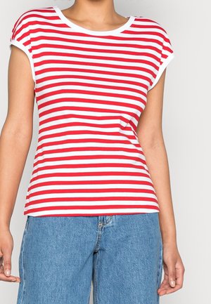 Kobieta nosząca czerwoną i białą koszulkę w poziome paski z krótkim rękawem, w połączeniu z wysokim stanem niebieskich dżinsów.