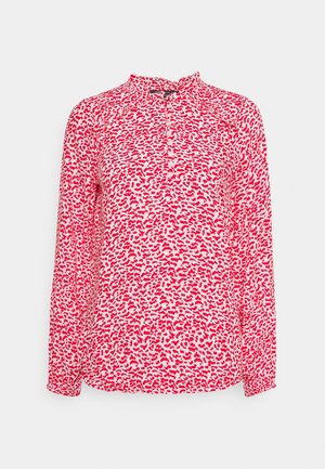 Rote und weiße Bluse mit langen Ärmeln, abstraktem Leopardenmuster, hohem Kragen und einer Reihe von Knöpfen auf der Vorderseite.