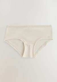 Culotte de bikini crème pour femme avec bordure en dentelle le long de la taille, en tissu lisse, posée à plat sur une surface claire.