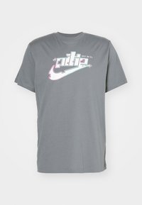 Šedé bavlněné tričko s krátkým rukávem, na přední straně s vícebarevným logem Nike a textem "Just Do It". Klasický střih, design s kulatým výstřihem.