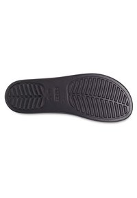 Semelle de chaussure en caoutchouc noir avec des motifs de grip texturés, présentant des rainures horizontales et verticales pour l'adhérence et la stabilité.