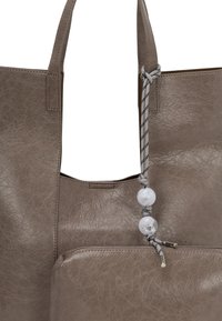 Borsa tote in pelle marrone con una finitura texturizzata, dotata di una tasca con zip e di un cordino annodato decorativo con perline trasparenti.