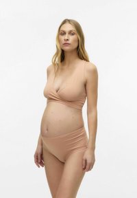 Zestaw bikini ciążowego w miękkim, nudowym kolorze. Posiada top w stylu kopertowym i spód od pasa w górę. Gładka tekstura z minimalną ilością szwów.