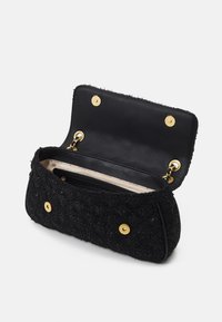 Black textured clutch bag with gold snap closures, beige interior lining, and a zippered pocket inside, shown open.