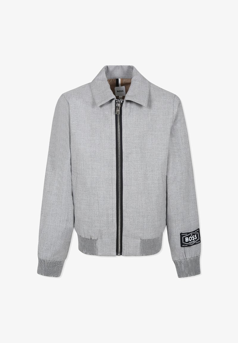 Giacca bomber grigia con zip frontale, polsini e orlo a costine. Presenta una patch con logo sulla manica e un collo strutturato. Tessuto dal tocco liscio.