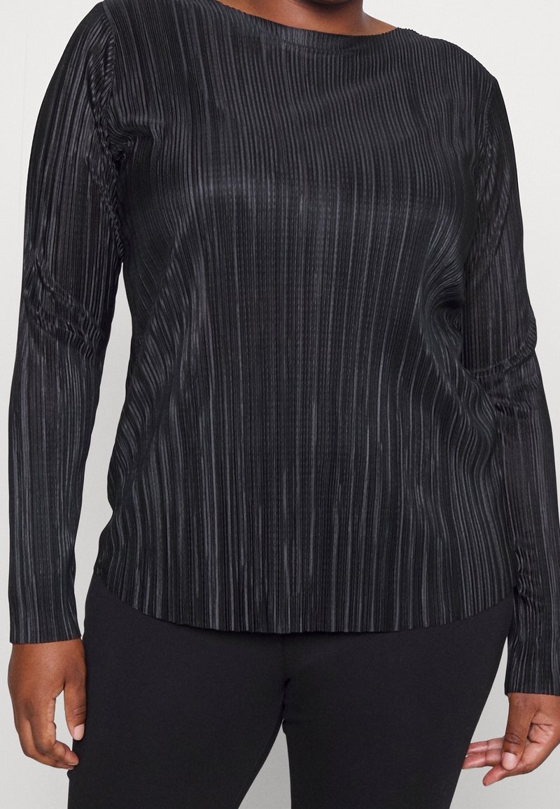 Top nero a maniche lunghe con texture a righe verticali, scollatura rotonda e polsini aderenti. Realizzato in un materiale morbido ed elastico.