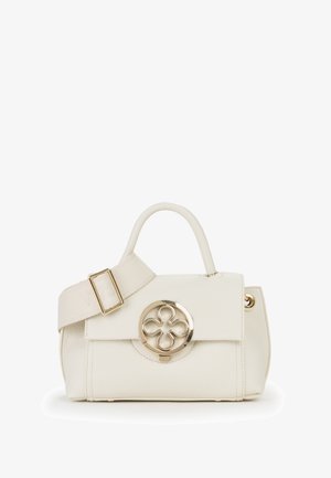 Handtasche in Cremefarbe mit kurzem Griff, breitem verstellbarem Riemen und rundem goldfarbenem Verschluss mit vierblättrigem Blumenmotiv.