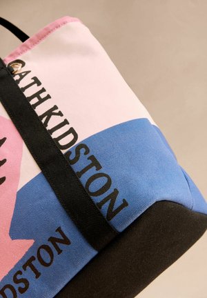Geantă tote din pânză cu secțiuni roz, albastre și negre, având un logo îndrăzneț "Cath Kidston". Textură mată și curea neagră durabilă.