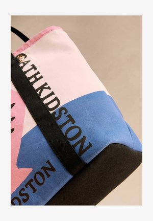 Lõuendist õlakott roosa, sinise ja musta osadega, millel on julge "Cath Kidston" logo. Matt tekstuur ja vastupidav must sang.