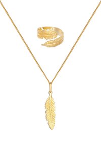 Goudkleurige juwelenset met een bladvormige hanger aan een fijne ketting en een bijpassende verstelbare ring met bladerenpatroon.