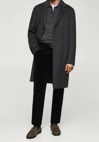 Cappotto in lana grigia, polo grigio carbone a maniche corte, pantaloni di corduroy neri e mocassini marroni. Vestibilità elegante e su misura. Design semplice e minimalista.