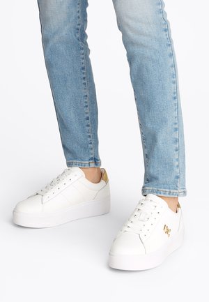 Λευκά δερμάτινα αθλητικά παπούτσια με σόλα πλατφόρμας, με χρυσές λεπτομέρειες στη φτέρνα και στο πλάι. Ο σχεδιασμός περιλαμβάνει διάτρητες λεπτομέρειες και κορδόνια.