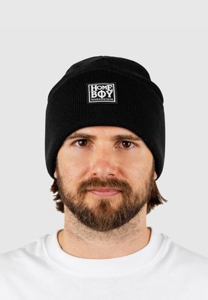 Black knitted beanie with a ribbed texture and a rectangular white patch labeled "HOME BOY loud-couture" at the front.