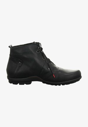 Bottines en cuir noir avec un bout rond, un laçage, un dessus texturé et une accent rouge près de la semelle. Semelle en caoutchouc avec adhérence.