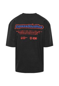 Schwarzes Baumwoll-T-Shirt mit kurzen Ärmeln. Auf der Rückseite befindet sich auffälliger roter und blauer Grafiktext, einschließlich Logo und Text. Normale Passform.