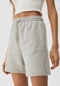 Lichtgrijze korte broek van een katoenmix met een elastische tailleband en een trekkoord. Voorzien van zijzakken en een ontspannen pasvorm. Zachte stoftextuur.