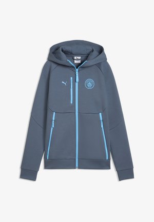 Ciemnoszara bluza z kapturem na zamek błyskawiczny, z jasnoniebieskimi zamkami, logo Puma i emblemat Manchester City na piersi.