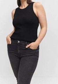Top de tirantes de canalé negro con cuello redondo, combinado con jeans ajustados gris oscuro. La tela parece suave y entallada, con bolsillos laterales.