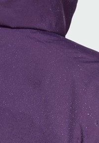Violetti kangas, jossa on sileä pinta ja pinnalla satunnaisesti olevia vesipisaroita, mikä viittaa vedenkestäviin ominaisuuksiin.