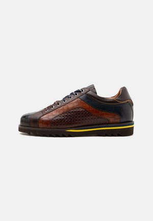 Herren-Turnschuh mit niedrigem Schaft aus braunem und dunkelblauem strukturiertem Leder, schwarzen Schnürsenkeln und schwarzer Sohle mit gelben und blauen Streifen.