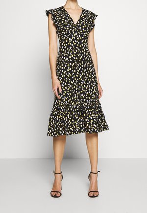 Czarna sukienka w kwiaty z dekoltem w serek, krótkimi falbanistymi rękawami, wzorami żółtych i białych kwiatów oraz warstwowym dołem. Noszona z czarnymi sandałkami na obcasie.