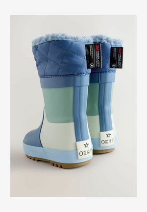 Bocanci din cauciuc impermeabili de culoare albastră, cu partea superioară quilted, secțiuni de culoare albastră deschisă și verde, și tălpi texturate. Au etichete albe cu inscripția "OKAY" pe călcâie.