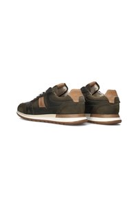 Donkergroene sneakers van suede en leer, met een tan accent op de hak, een witte zool en textuurdetails.
