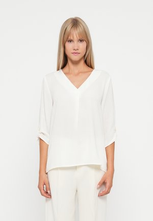 Weiße, leichtgewichtige Bluse mit V-Ausschnitt, Dreiviertelärmeln und umgeschlagenen Bündchen. Glatte Textur mit minimalistischem Design.