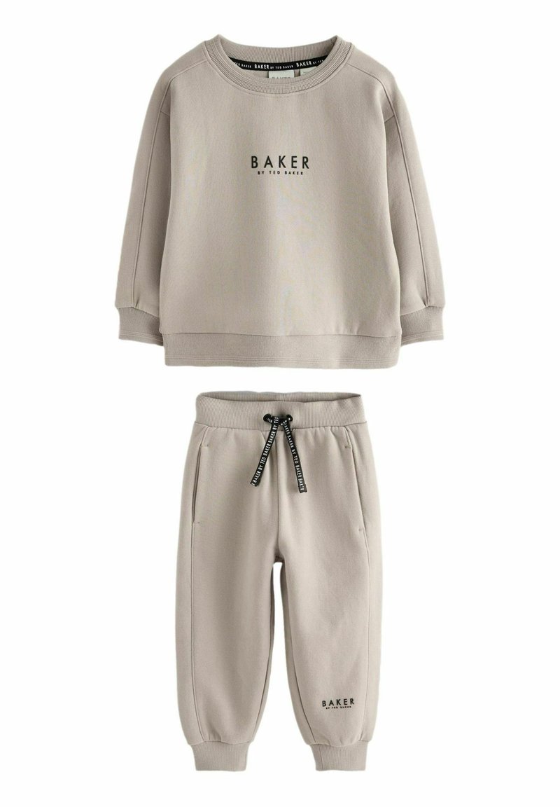 Sweatshirt gris clair et joggeurs assortis en tissu doux. Présente un logo « BAKER » noir et un cordon de serrage ajustable. Coupe décontractée, poignets côtelés.
