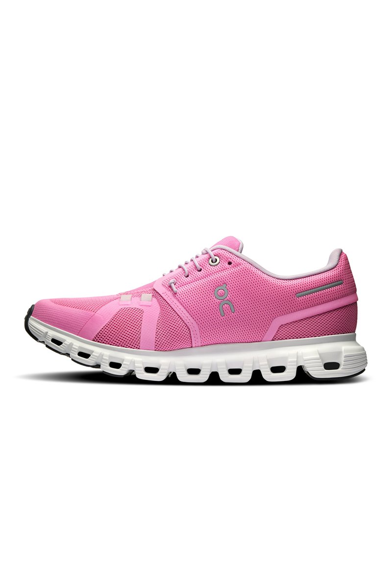 Zapatillas deportivas rosas con parte superior de malla y suela blanca. Incluyen un dedo del pie redondeado, cierre de cordones y acentos texturizados en el lateral.