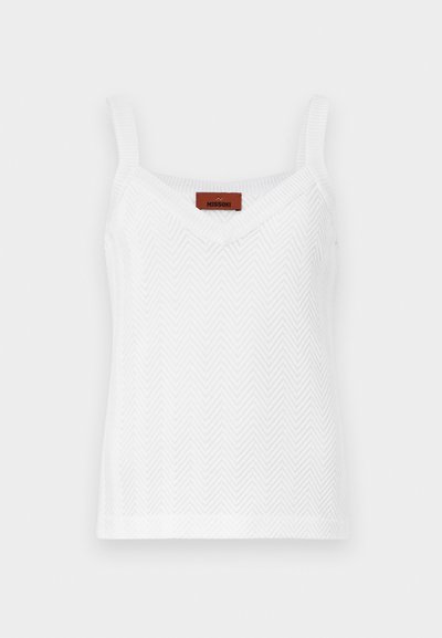 Balta mezginė tank top su žuvies kaulų raštu, turinti plonas petnešas ir V formos kaklą. Etiketėje yra prekės ženklo pavadinimas "Missoni."