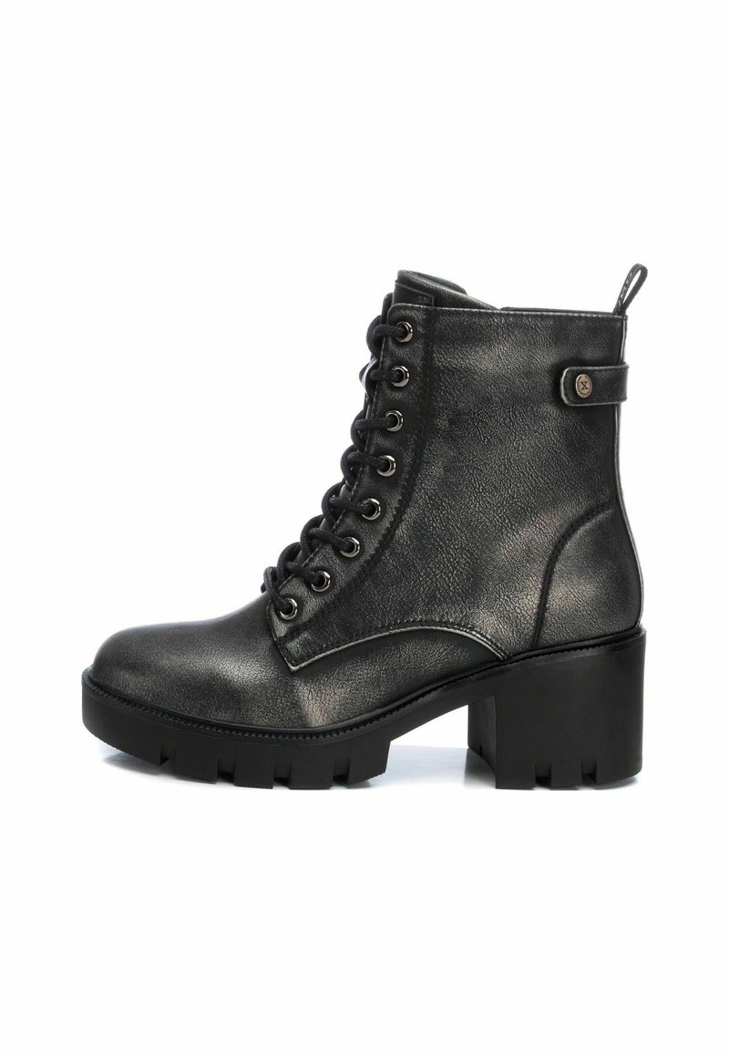 Black leather lace-up ankle boot with chunky heel and treaded sole, featuring a side strap with a metal button detail.