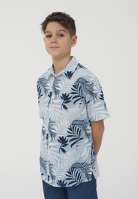 Camicia a maniche corte in tessuto azzurro chiaro con motivi a foglia blu navy scuro e bottoni in legno. Design semplice e vestibilità rilassata.