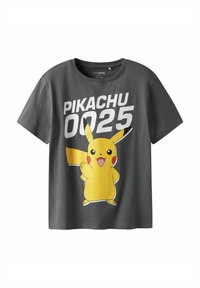 Pilkas medvilninis marškinėliai su dideliu Pikachu grafiką geltona spalva, raudonomis skruostomis ir tekstu "PIKACHU 0025" balta spalva per priekinę pusę.