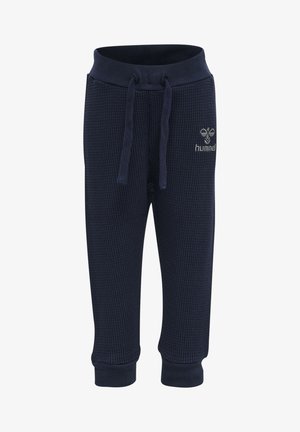 Marina-blå sweatpants i våfflat tyg med elastisk midja, justerbar dragsko och ribbade ärmslut. Har en logotyp på framsidan.