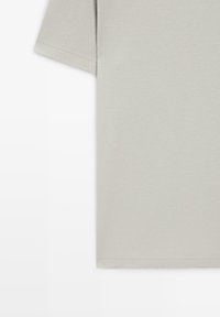 Lysegrå kortærmet bomulds-T-shirt med enkelt design og synlige sømme på ærmet og nederste kant.