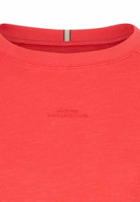 Rode sweatshirt met een ronde hals, met een zachte textuur. De voorkant toont reliëftekst "MADE FOR DAILY ADVENTURES."