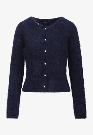 En mørkeblå cardigan laget av fluffy materiale, med lange ermer, rund halslinning og seks hvite knapper foran.