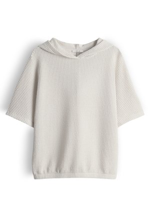 Weißes, kurzärmeliges Kapuzenoberteil aus Waffelstrick mit lockerem Sitz und kleinem Markenlabel im Nackenbereich.