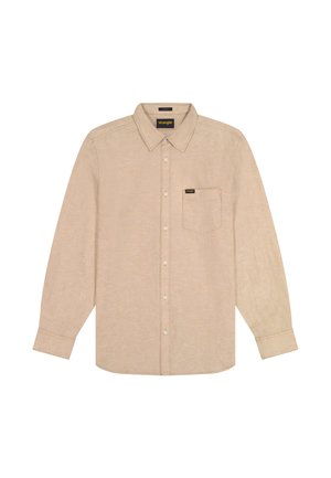 Camisa beige de manga larga con botones, cuello y un único bolsillo en el pecho, con el logo de Wrangler en el bolsillo y etiqueta interior en el cuello.