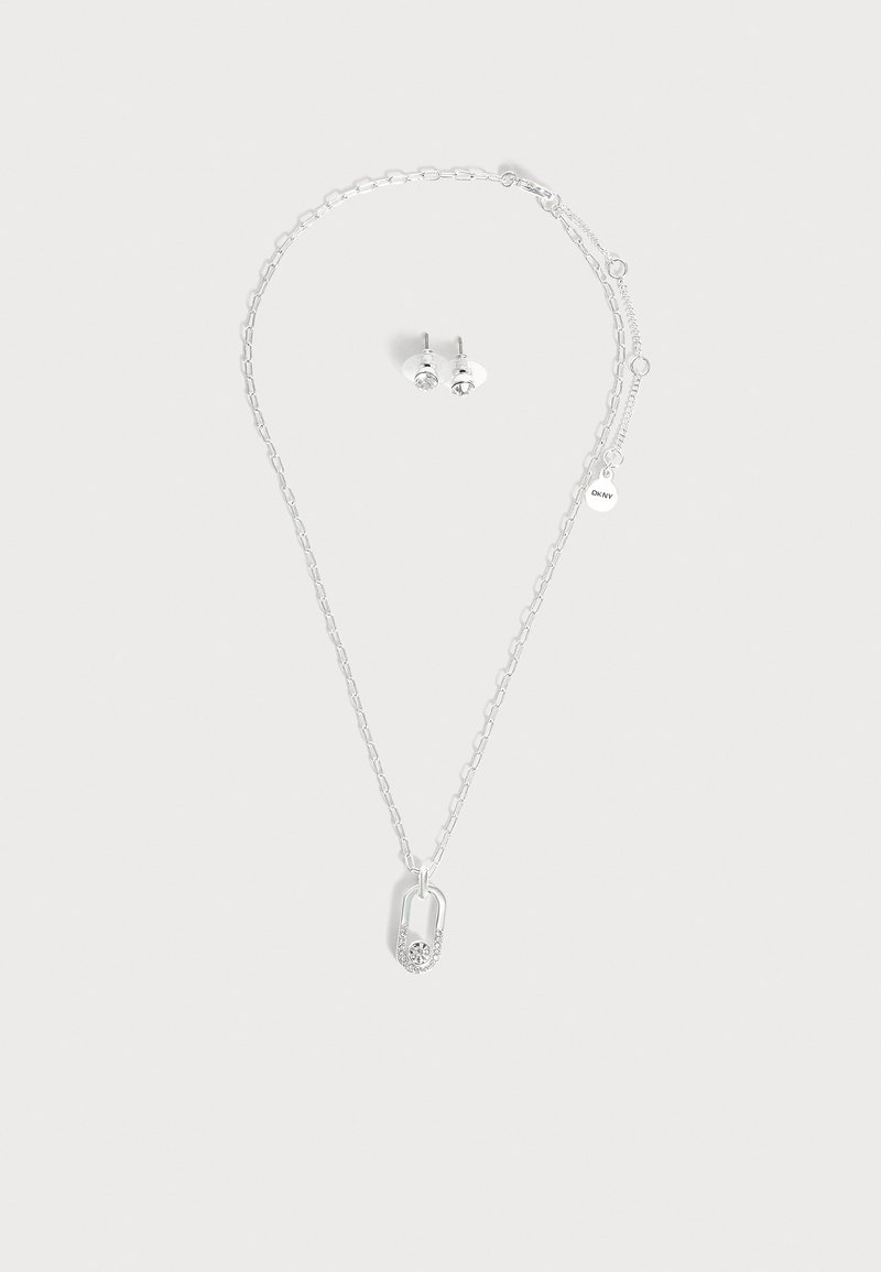 Collier chaîne en argent avec un pendentif en forme de cadenas orné de petits cristaux et boucles d’oreilles clous assorties avec des pierres claires.